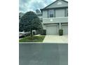 Charming townhome showcasing a well-manicured lawn with mature landscaping and individual driveway at 135 Heritage Park St, Winter Springs, FL 32708
