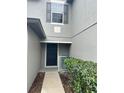 Inviting front entrance with a dark-colored door, complemented by lush green shrubbery and white railings at 135 Heritage Park St, Winter Springs, FL 32708