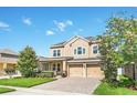 Charming two-story home with a two-car garage and colorful landscaping, creating an inviting curb appeal at 1545 Caterpillar St, St Cloud, FL 34771