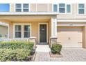 Close-up of a home entrance featuring manicured bushes, stone pillar accents, and a gray front door at 1545 Caterpillar St, St Cloud, FL 34771