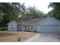 Well-lit single story home featuring mature landscaping and a two car garage at 1644 Cypress Woods Cir, St Cloud, FL 34772