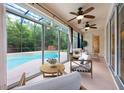 Bright sunroom with screened windows overlooking the pool area and stylish furniture at 16500 Cedar Run Dr, Orlando, FL 32828