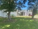 Charming home exterior featuring a well-manicured lawn, mature trees, and a convenient golf cart at 1707 E Schwartz Blvd, Lady Lake, FL 32159