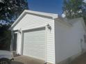 Detached white garage with white doors, matching siding, and decorative lanterns at 1707 E Schwartz Blvd, Lady Lake, FL 32159