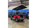 Back view of a new red Advanced EV golf cart with black seats and a roof at 1707 E Schwartz Blvd, Lady Lake, FL 32159