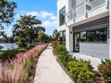 Contemporary townhome exterior with a scenic walkway, lush landscaping, and waterfront access at 1764 Mondrian Cir, Winter Park, FL 32789