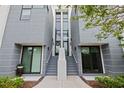 Modern townhome with a gray exterior and a stairway leading to a central entrance at 1764 Mondrian Cir, Winter Park, FL 32789
