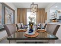 Elegant dining room featuring stylish decor, a modern light fixture, and a glass-top table set for a dinner party at 2624 Daulby St, Kissimmee, FL 34747