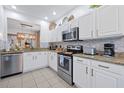 Bright kitchen with white cabinets, granite countertops, stainless steel appliances, and modern tile flooring and backsplash at 2624 Daulby St, Kissimmee, FL 34747