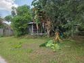 Exterior view with large picture windows on one side surrounded by overgrown greenery at 2638 S Laurel Ave, Sanford, FL 32773