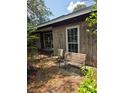Seating area in front yard with weathered bench and chairs, shaded by mature trees at 2638 S Laurel Ave, Sanford, FL 32773