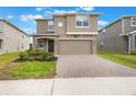 Charming two-story home featuring a two-car garage, neutral stucco exterior, and a neatly paved driveway at 2932 Muller Oak Loop, Ocoee, FL 34761