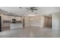 Bright open-concept living area with tile flooring, ceiling fan, and seamless flow into the adjacent kitchen at 2932 Muller Oak Loop, Ocoee, FL 34761
