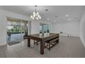 Open dining area with tile flooring, sliding glass doors, recessed lighting, and an elegant chandelier at 3966 Steer Beach Pl, Kissimmee, FL 34746