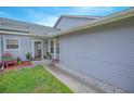 Close up of home showing covered front entry with green grass and gray siding at 4541 Southfield Ave, Orlando, FL 32812