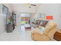 Cozy living room featuring neutral tile flooring and sliding glass doors leading to an outdoor space at 4541 Southfield Ave, Orlando, FL 32812