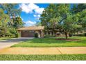 Charming single-story home with a well-manicured lawn, mature trees, and a paved driveway at 477 Eagle Brook Ct, Debary, FL 32713