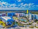 Aerial view of a vibrant condo community with landscaped grounds, a tennis court, and ample parking at 5 Riverwalk Dr # 601, New Smyrna Beach, FL 32169
