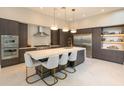 Modern kitchen boasts a large island, stainless steel appliances, and stylish pendant lighting at 5023 Sawyer Cove Way, Windermere, FL 34786