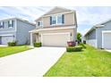 Attractive home featuring a two-car garage, a green lawn, and great curb appeal at 5164 Chickadee St, St Cloud, FL 34771