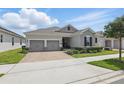 Well-kept single Gathering home boasts of two-car garage, manicured landscaping, and a brick paver driveway at 5427 Orange Orchard Dr, Winter Garden, FL 34787
