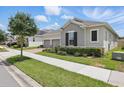 Attractive home with a two car garage, verdant lawn, trimmed shrubs and a brick paver driveway at 5427 Orange Orchard Dr, Winter Garden, FL 34787