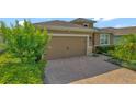 A paved driveway leads to a two-car garage door with a well-maintained landscape at 553 Adenmore Ter, Deland, FL 32724
