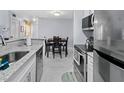 Modern kitchen with stainless steel appliances, white cabinets and a view into the dining area at 6100 Westgate Dr # 101, Orlando, FL 32835