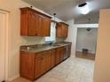 Traditional kitchen featuring wood cabinets, granite countertops, stainless steel appliances, and tile flooring at 618 Meadow Park Dr, Minneola, FL 34715