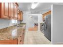 Bright kitchen showcases granite counters, stainless appliances, and tile flooring at 618 Meadow Park Dr, Minneola, FL 34715
