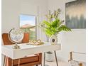 Close-up of office decor: white desk with globe, plants, leather chair, and neutral artwork at 6384 Chorus Dr, Mascotte, FL 34753