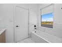 Clean, bright bathroom features a soaking tub with modern fixtures and a window for natural light at 6427 Chorus Dr, Mascotte, FL 34753