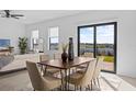 Open concept dining area with modern table, chairs and sliding doors to the outdoor space and stunning views at 6427 Chorus Dr, Mascotte, FL 34753