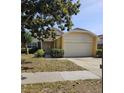 Well-maintained single-Gathering home featuring a two-car garage, manicured lawn, and inviting entrance at 7228 Spring Villas Cir, Orlando, FL 32819