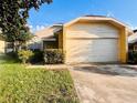 Quaint single-Gathering home featuring a spacious garage, complemented by lush greenery and mature trees at 7228 Spring Villas Cir, Orlando, FL 32819