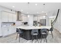 Modern kitchen featuring a large center island, granite countertops, stainless steel appliances, and stylish pendant lighting at 7873 Dausset St, Orlando, FL 32827