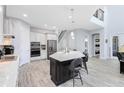 Bright kitchen with a large island, stainless steel appliances, and seamless flow to the staircase and other living areas at 7873 Dausset St, Orlando, FL 32827