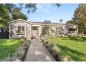 Charming home featuring a well-manicured front yard, a decorative flower boxes, and beautiful landscaping at 100 Kennison Dr, Orlando, FL 32801