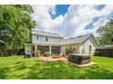 A spacious backyard featuring a patio, a fire pit, a jacuzzi, and lush green grass at 101 W Oakland Ave, Oakland, FL 34760
