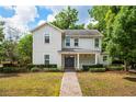Charming two-story home featuring a landscaped front yard and inviting front porch at 101 W Oakland Ave, Oakland, FL 34760