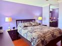 Serene bedroom featuring a comfortable bed, stylish lamps, and calming purple walls at 10125 Matchlock Dr, Orlando, FL 32821