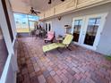 Covered patio with brick flooring, stylish lounge chairs, ceiling fan, and ample space for outdoor seating at 10125 Matchlock Dr, Orlando, FL 32821