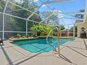 Inviting pool in screened lanai, surrounded by lush greenery at 1024 Destin Dr, Lake Wales, FL 33898