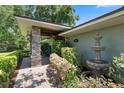 Welcoming front entrance featuring a stone pillar porch, fountain, lush greenery, and elegant lighting at 103 Greenleaf Ln, Altamonte Springs, FL 32714