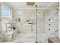 Modern bathroom features a glass shower, gold fixtures, marble tiling, and a built-in bench at 1082 Trappers Trail Loop, Davenport, FL 33896