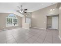 Bright living room with vaulted ceilings, ceiling fan, neutral paint, and tile flooring throughout at 12832 Downstream Cir, Orlando, FL 32828