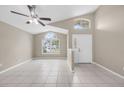 Bright living room with vaulted ceilings, ceiling fan, neutral paint, and tile flooring throughout at 12832 Downstream Cir, Orlando, FL 32828
