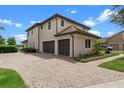 Spacious three-car garage with a paved driveway and lush landscaping at 13120 Zori Ln, Windermere, FL 34786