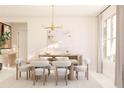 Elegant dining room featuring modern chandelier, neutral tones, and ample natural light from large windows at 13181 Telsen St # 39, Winter Garden, FL 34787