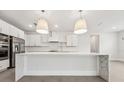 Modern kitchen featuring white cabinets, quartz countertops, and stainless steel appliances with large island at 13181 Telsen St # 39, Winter Garden, FL 34787